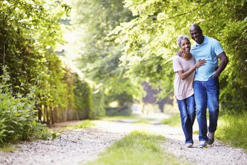 Mid aged couple walk green trail near United Smile Centres in Louisville, KY.