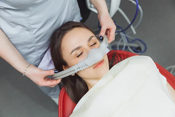 Image of a dental professional getting a female patient ready for dental sedation, at United Smile Centres.