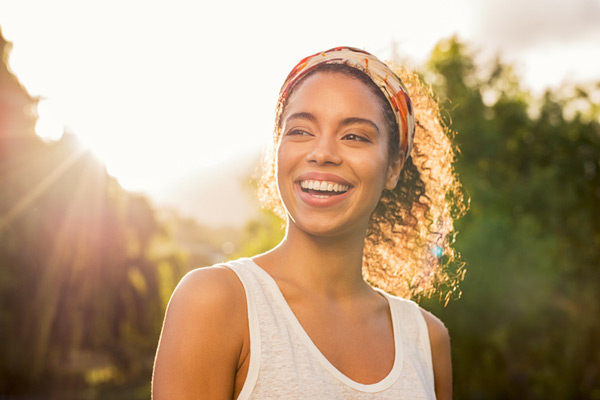 Black woman smiling in the sun after appointment at United Smile Centres in Louisville, KY