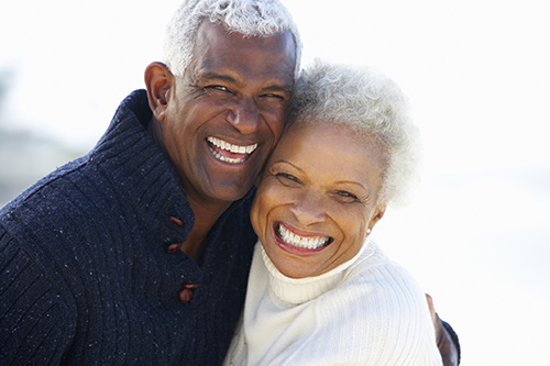 Older Black couple smiling after getting dental implants done at United Smile Centres in Louisville, KY 
